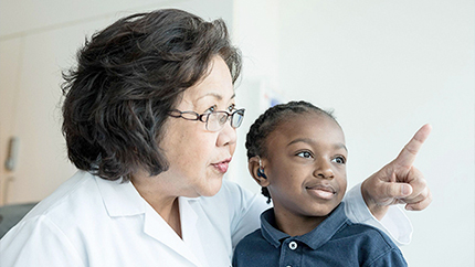 doctor and pediatric patient looking at something in the background